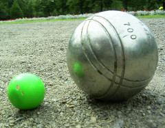 Image d'un but et d'une boule de pétanque sur du gravier
