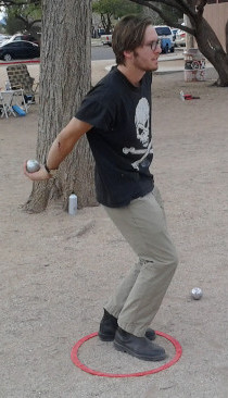 Image of a petanque player throwing from within a prefabricated circle